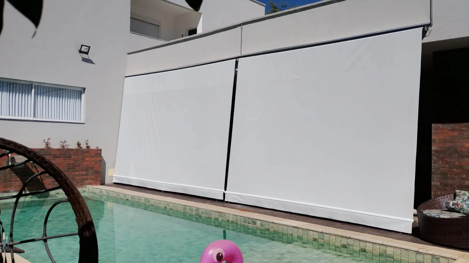 Toldo retrátil fechado protegendo área de piscina